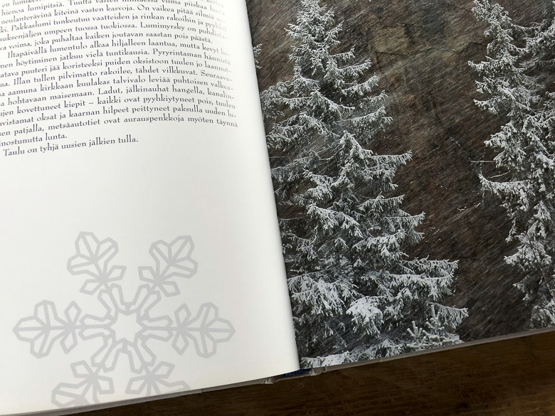 Lumihiutaleita tekstisivulla ja kuusten oksilla